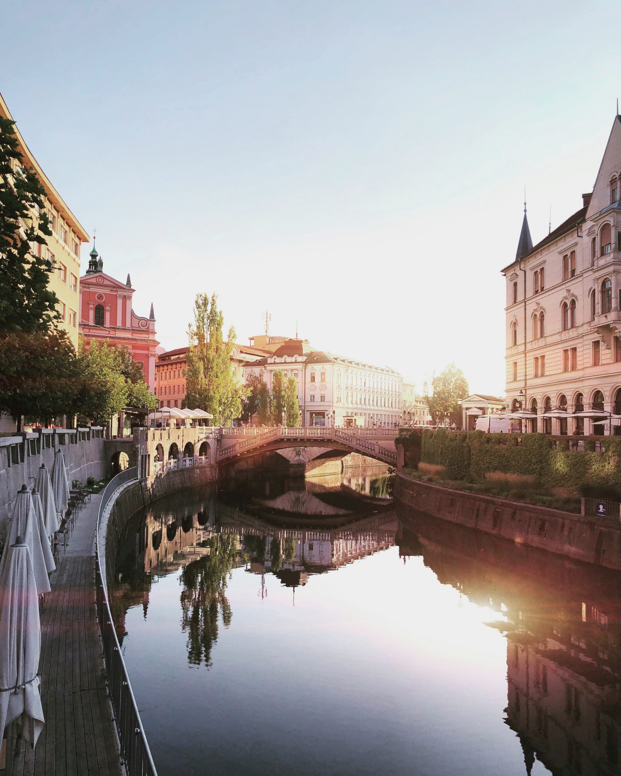 Ljubljana riverfront and historic architecture at sunset.